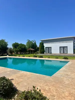 a swimming pool in front of a building at Ferme moderne avec piscine et jardin Sejour paisible au cœur de la nature in Berrechid