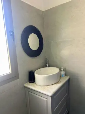 a bathroom with a sink and a mirror on a counter at Ferme moderne avec piscine et jardin Sejour paisible au cœur de la nature in Berrechid