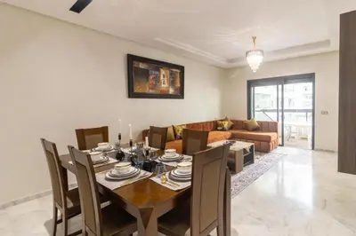 a dining room with a table and chairs and a couch at Beautiful apartment with pool view in Aïn Harrouda