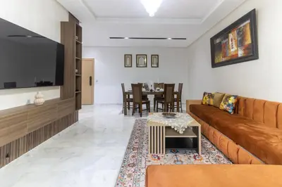 a living room with a couch and a table at Beautiful apartment with pool view in Aïn Harrouda