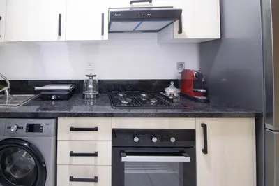 a kitchen with a stove and a washer and dryer at Beautiful apartment with pool view in Aïn Harrouda