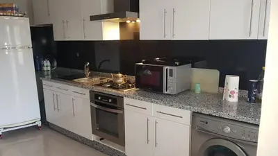 a kitchen with a counter top with a microwave at apparttement confort residence marina beach a mohammedia in Mohammedia
