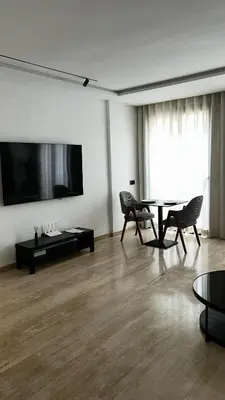 a living room with a table and chairs and a tv at Prestige Aman in Casablanca