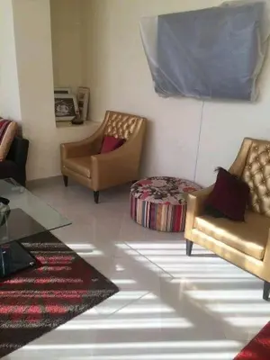 a living room with two chairs and a table at appartement a la residence marina beach a mohammedia plage in Mohammedia