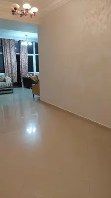 a living room with a white wall and a couch at appartement a la residence marina beach a mohammedia plage in Mohammedia
