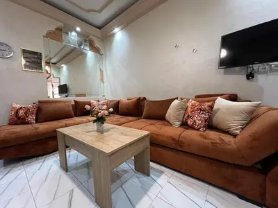 a living room with a brown couch and a table at Super apartment Near Hassan II Mosk and Corniche in Casablanca