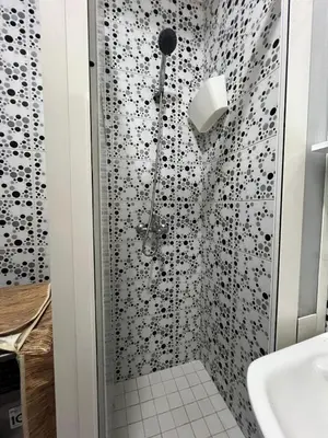 a bathroom with a shower with black and white tiles at Super apartment Near Hassan II Mosk and Corniche in Casablanca