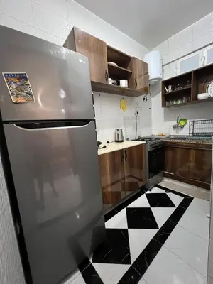 a kitchen with a refrigerator and a black and white checkered floor at Super apartment Near Hassan II Mosk and Corniche in Casablanca