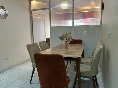 a dining room table with chairs and a vase of flowers on it at Super apartment Near Hassan II Mosk and Corniche in Casablanca