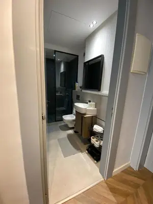 a bathroom with a toilet and a sink and a television at Cosy & Modern apartment with balcony, fiber WiFi & air conditioning Close To KFC & Mcdo Bd 2 Mars In The Heart Of Casablanca in Casablanca