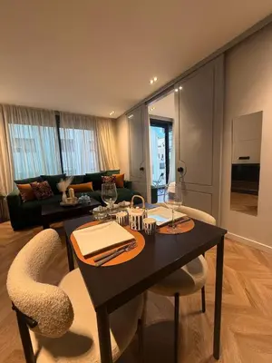 a living room with a table and two chairs at Cosy & Modern apartment with balcony, fiber WiFi & air conditioning Close To KFC & Mcdo Bd 2 Mars In The Heart Of Casablanca in Casablanca