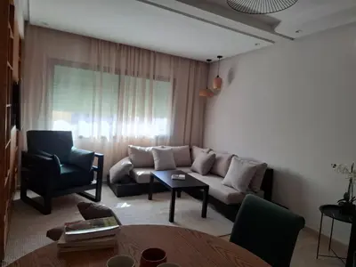 a living room with a couch and a chair at Bel appartement 2 chambres à Bourgogne in Casablanca