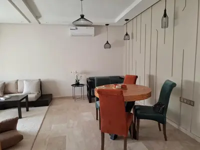 a living room with a table and chairs and a couch at Bel appartement 2 chambres à Bourgogne in Casablanca