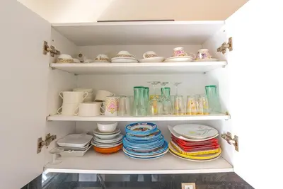 a cupboard filled with plates and bowls and dishes at Spacious luxury apartment with pool in Bouznika
