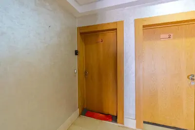 an empty room with two doors and a red object at Spacious luxury apartment with pool in Bouznika