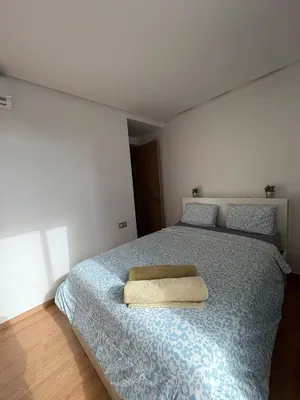 a bedroom with a bed with a blue comforter and two pillows at Chic One Bedromm Apartment - Large Terrace - Anfa District in Casablanca