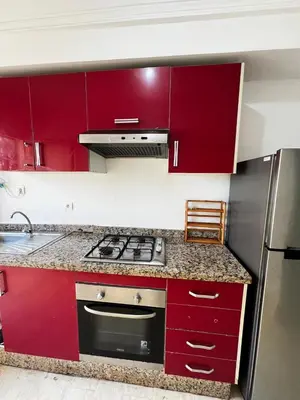 a kitchen with red cabinets and a stove at Maison Vacances in Casablanca