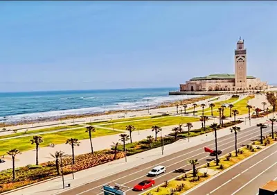 a road with a clock tower on the beach at Maison Vacances in Casablanca