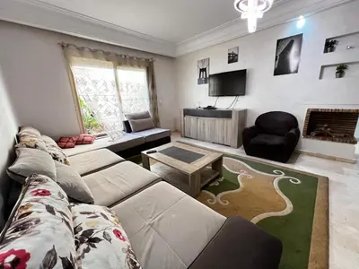 a living room with a couch and a tv at Maison Vacances in Casablanca