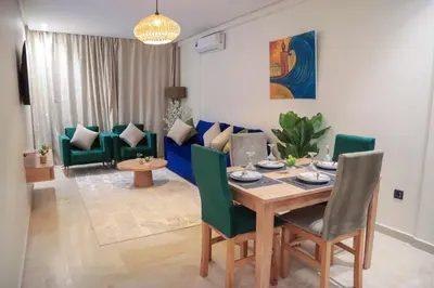 a living room with a wooden table and green chairs at R107- Incredible 1BR Apartment with King size bed and Green Balcony in Casablanca