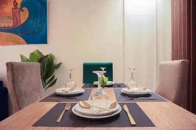 a dining room table with plates and glasses on it at R107- Incredible 1BR Apartment with King size bed and Green Balcony in Casablanca