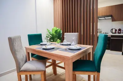 a dining room table with green chairs and a table at R107- Incredible 1BR Apartment with King size bed and Green Balcony in Casablanca