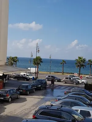 a parking lot with cars parked next to the ocean at Apartment at Melissa's, sea view, Res Assabah in Rabat