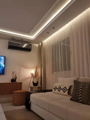 a living room with a couch and a television at Blue paradise in Rabat