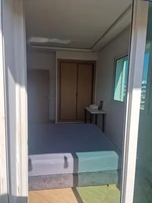 a bedroom with a bed and a desk in it at APPARTEMENT DE LUXE 3 Façades in O Ben Slimane