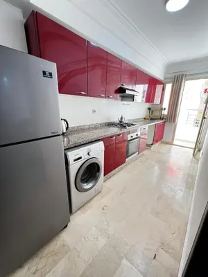 a kitchen with red cabinets and a washer at Complexe Horizon in Casablanca