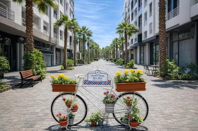 a bike parked on a street with flowers and palm trees at Walkable, Beach in 2, Terrace, DW, AC, PS4, WiFi in Mohammedia