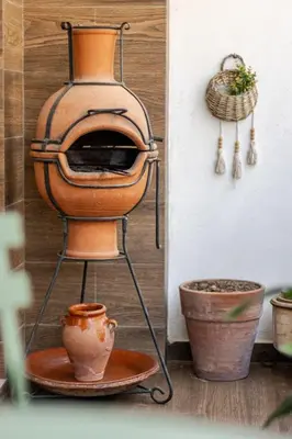 a wood fired oven on a stand next to some pots at Walkable, Beach in 2, Terrace, DW, AC, PS4, WiFi in Mohammedia
