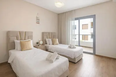 a bedroom with two beds and a large window at Walkable, Beach in 2, Terrace, DW, AC, PS4, WiFi in Mohammedia