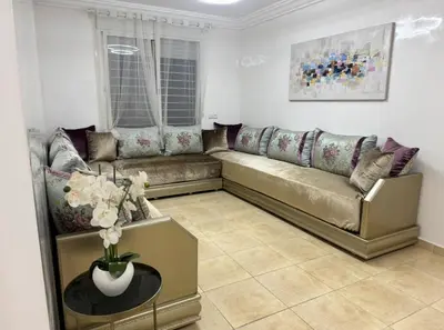 a living room with a couch and a vase of flowers at Blue Ocean Escape Sidi Rhal in Sidi Rahal