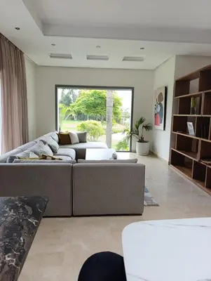 a living room with a couch and a large window at Hamza in Temara