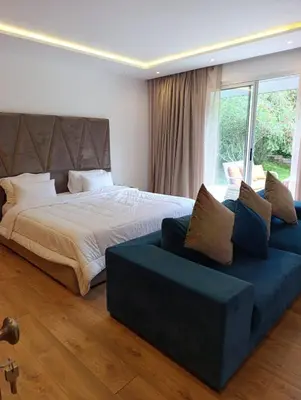 a bedroom with a large bed and a blue couch at Hamza in Temara
