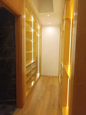 a walk in closet with wooden floors and shelves at Hamza in Temara