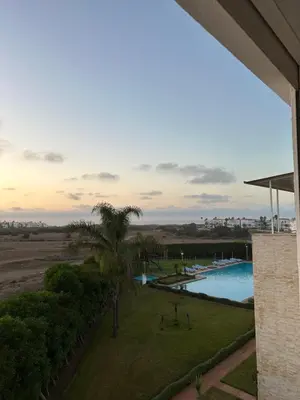 a view of the pool from the balcony of a resort at Appartement Cosy Bord de Mer in Dar Mohammed Ould Haj Jilali