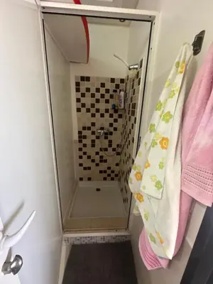 a shower with a glass door in a bathroom at Appartement Cosy Bord de Mer in Dar Mohammed Ould Haj Jilali