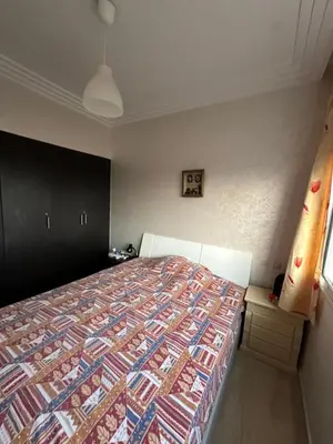 a bedroom with a bed with a colorful quilt at Appartement Cosy Bord de Mer in Dar Mohammed Ould Haj Jilali