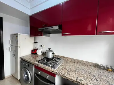 a kitchen with red cabinets and a stove top oven at Morocco House in Casablanca