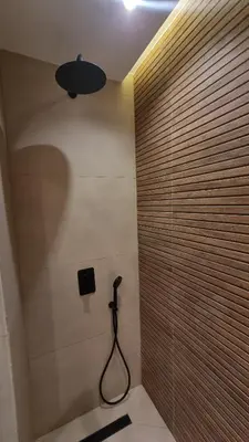 a bathroom with a shower with a hose on the wall at majorelle luxury in Rabat