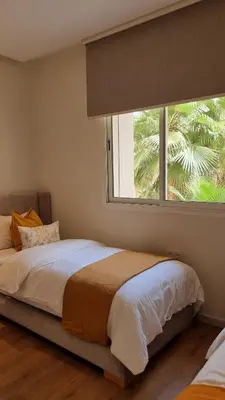 a bedroom with a bed and a large window at majorelle luxury in Rabat