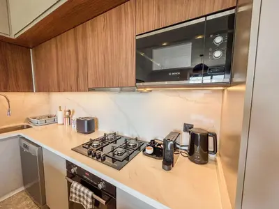 a kitchen with a stove and a microwave at CFC Casablanca - Luxury 1-Bedroom Apartment with Anfa Park View in Casablanca