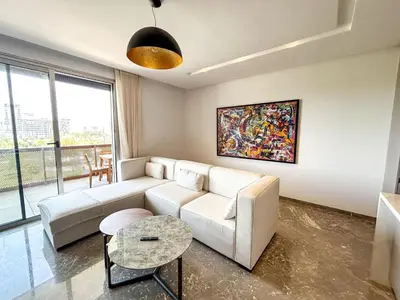 a living room with a couch and a table at CFC Casablanca - Luxury 1-Bedroom Apartment with Anfa Park View in Casablanca