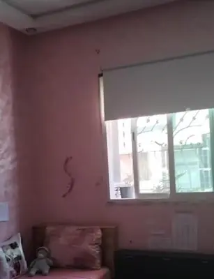 a room with a window and a couch with a snake on the wall at Appartement Jad in Deroua