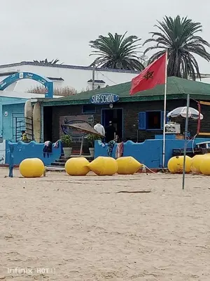 a building on the beach with yellow inflatables at Duplex moderne avec jardin privé 5 min de la mer in Skhirat
