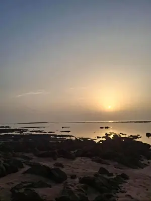 a sunset over the ocean with rocks in the water at Duplex moderne avec jardin privé 5 min de la mer in Skhirat