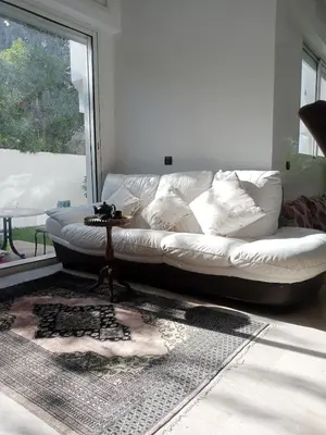 a white couch in a living room with a window at Duplex moderne avec jardin privé 5 min de la mer in Skhirat
