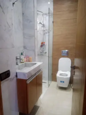 a bathroom with a toilet and a sink and a shower at Duplex moderne avec jardin privé 5 min de la mer in Skhirat